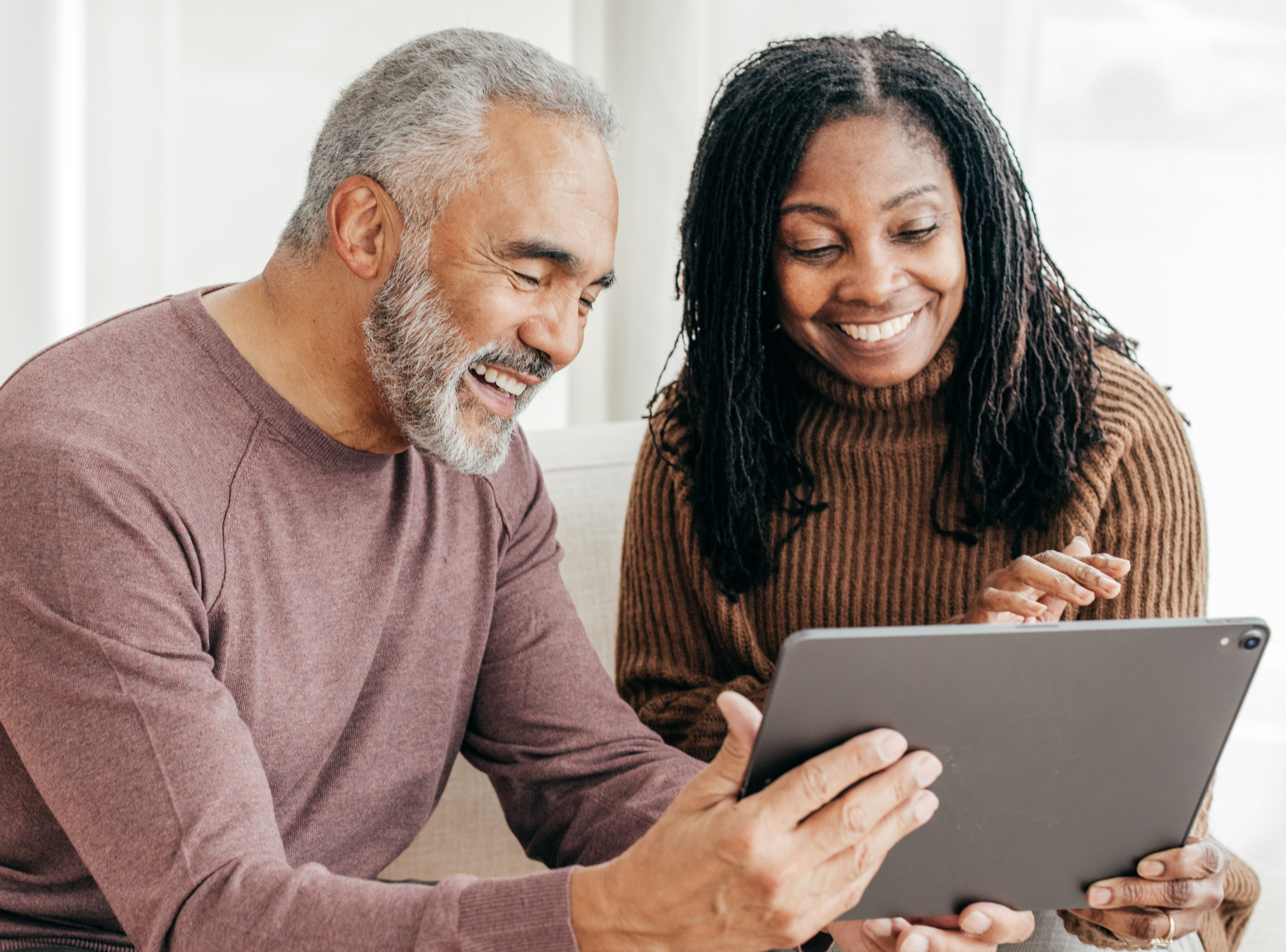 Senior women and senior men use a  tablet during the Winter Holidays