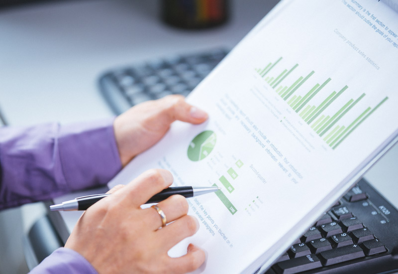 A woman reviews a packet of graphs