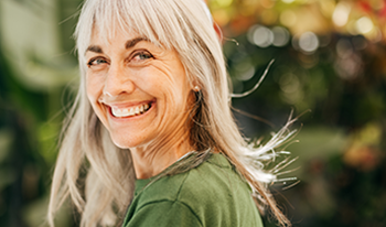 An older woman smiles at the camera
