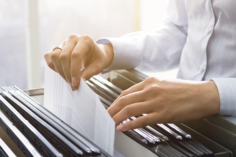Office clerk searching files in the filing cabinet