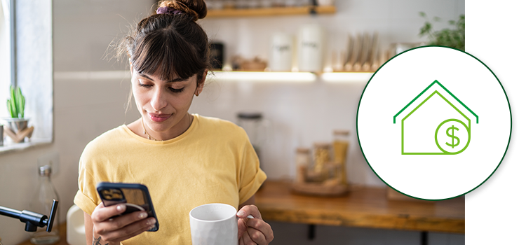 A woman looks at her phone with a cup of coffee