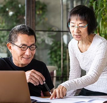 A couple with glasses work out their finances together