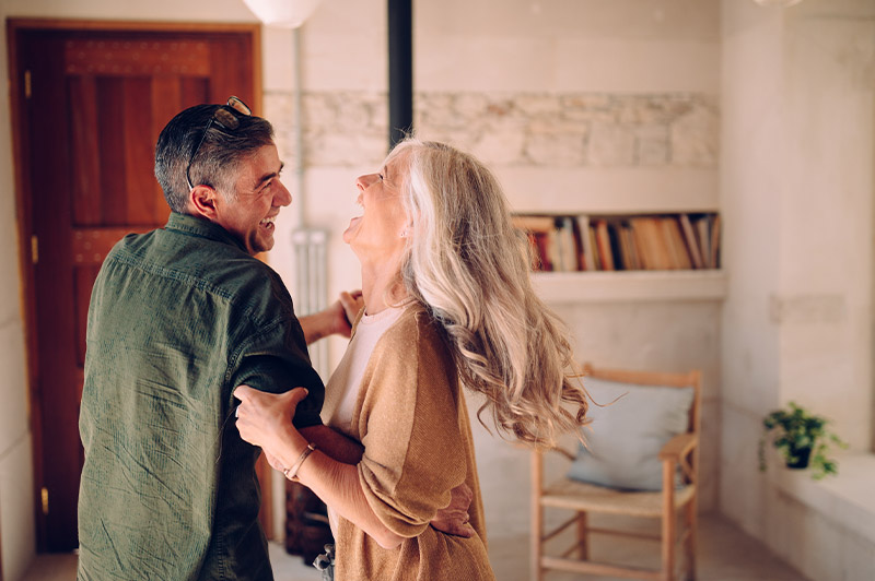 Happy couple dancing in living room