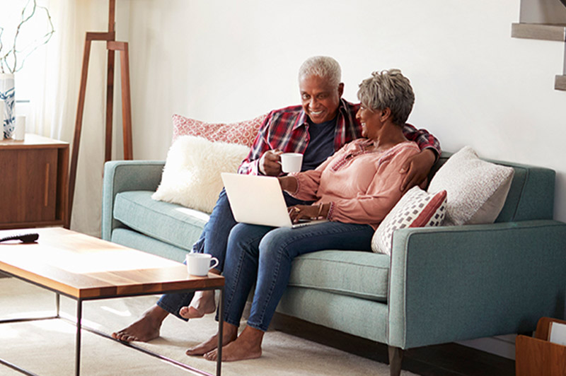 Elderly couple on the couch with a laptop