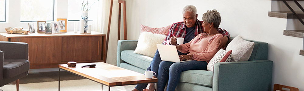 Elderly couple on the couch with a laptop