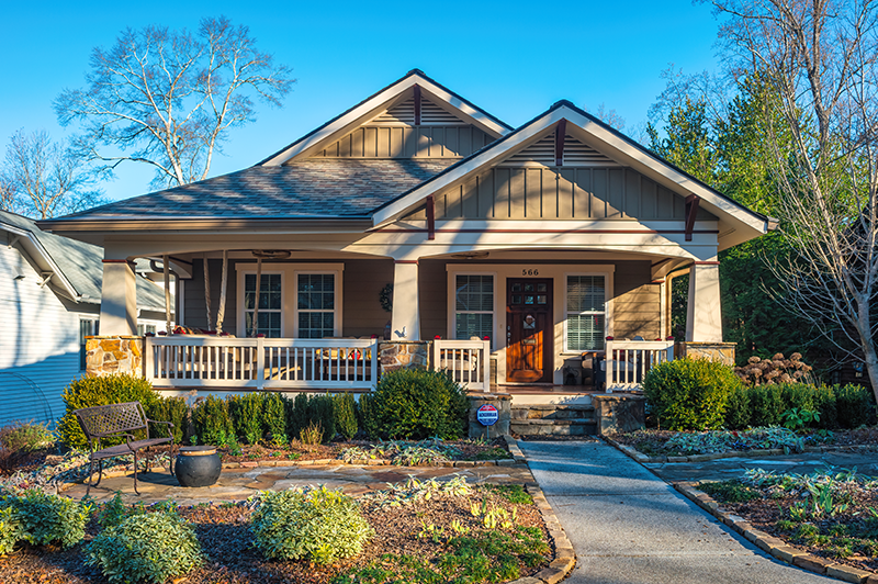 A house with a porch as the sun sets on it