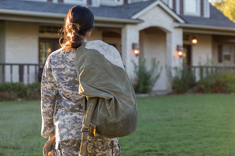 A veteran with their rucksack, returns home