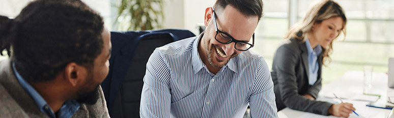 Happy businessman signing paperwork on a meeting in the office.