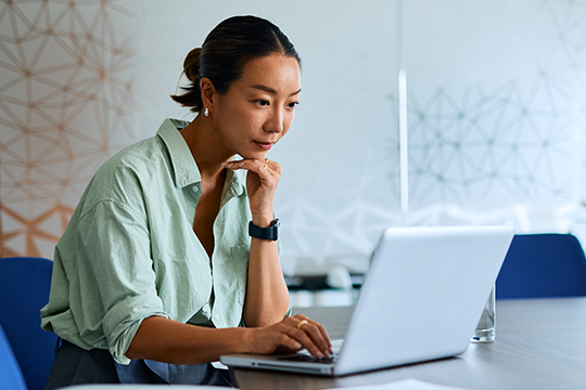 A business woman looks at laptop